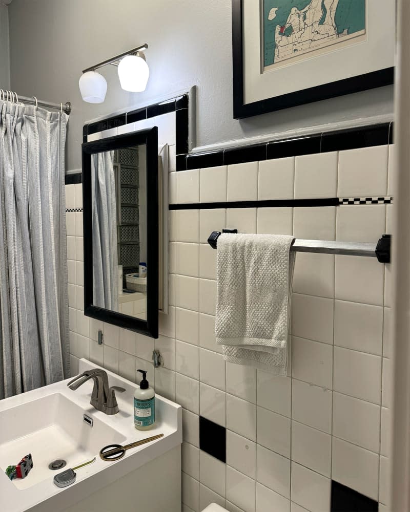 Black and white tiles in bathroom before renovation.