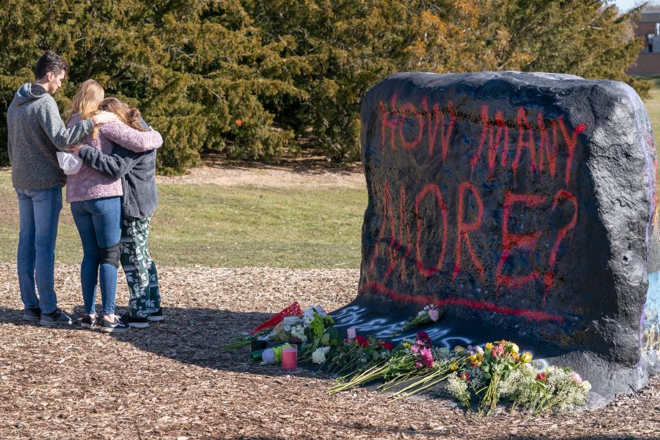 Denver Rayl, 20, an MSU junior in history, left, and his girlfriend Jessica Bailey, 19, a sophomore genetics major, comfort Marissa Gable, 19, a sophomore criminal justice major, as they gather at The Rock on the campus of MSU on Tuesday, Feb. 14, 2023, to mourn fellow students a day after a gunman killed three MSU students and injured five more people.