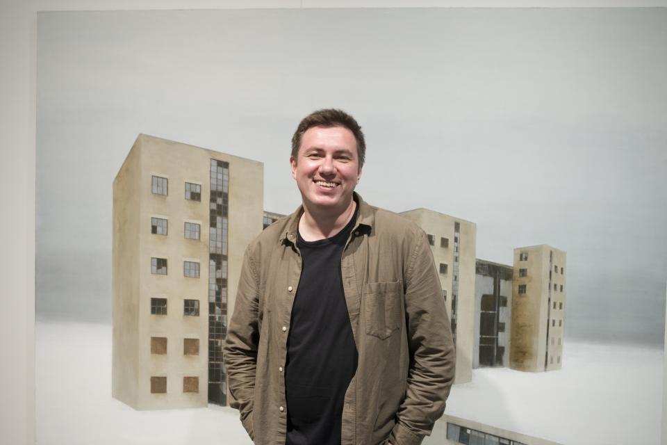 In this handout photo taken in 2018, Pavel Otdelnov, a Russian artist poses for a photo in front of his work "Ruins. Building 538» in Moscow, Russia . Pavel Otdelnov, a Russian artist who grew up in Dzerzhinsk, the center of the nation's chemical industries 355 kilometers (220 miles) east of Moscow, focused on the city, one of the most polluted in Russia, in his new 'Promzona' art show. (Pavel Otdelnov, Photo via AP)