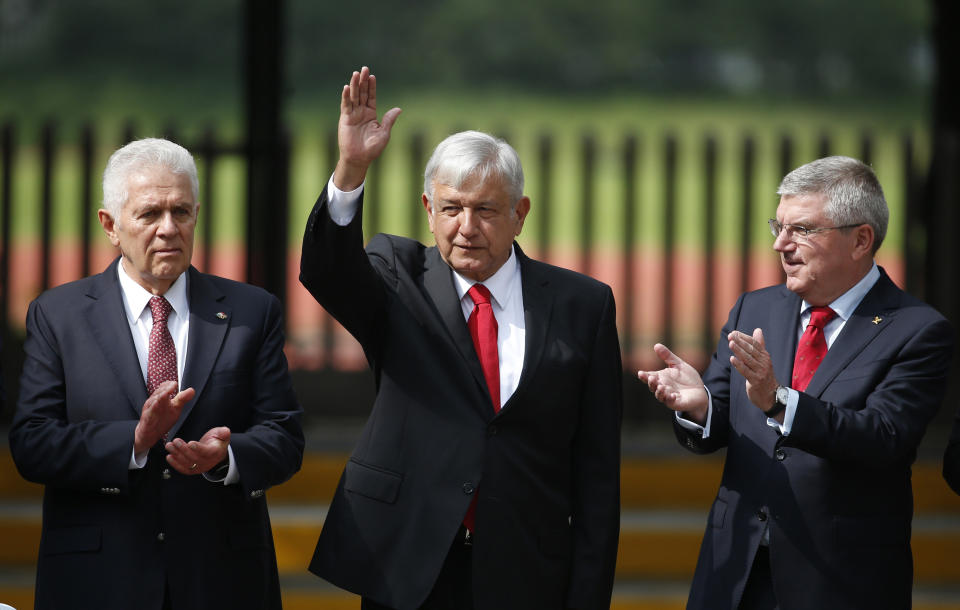 President-elect Andres Manuel Lopez Obrador, center, is applauded by Mexican Olympic Committee President Carlos Padilla Becerra, left, and International Olympic Committee President Thomas Bach, as he is introduced during an event at the headquarters of the Mexican Olympic Committee in Mexico City, Thursday, Sept. 27, 2018. Bach is visiting Mexico on the 50th anniversary of the 1968 Olympics in Mexico City. (AP Photo/Rebecca Blackwell)
