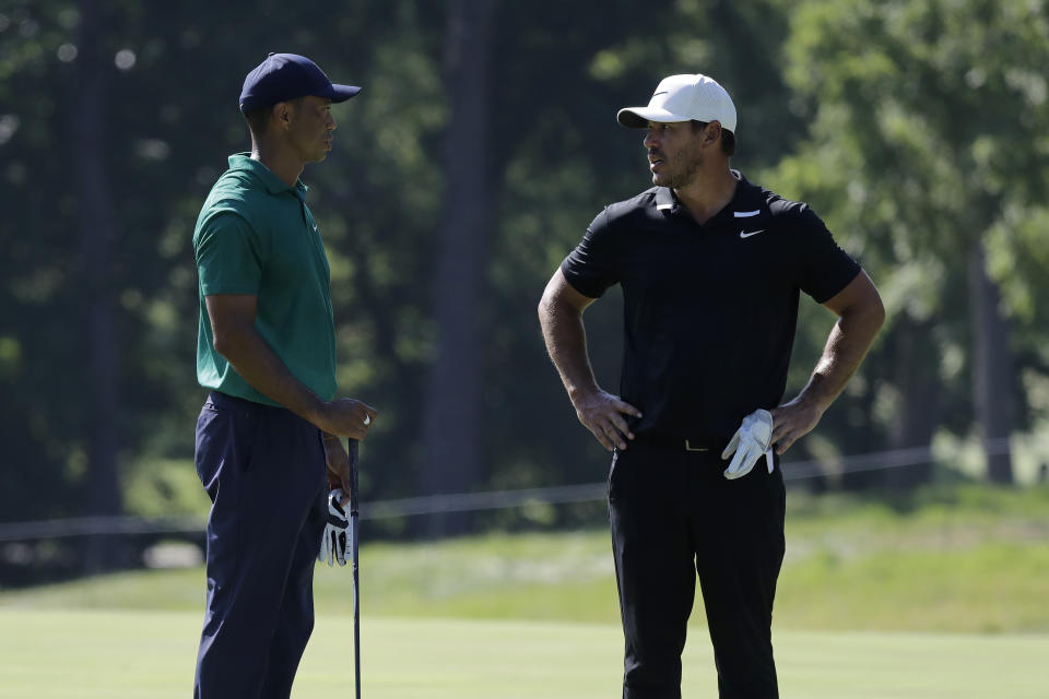 Tiger Woods, left, talks with Brooks Koepka on the 11th fairway during the third round of the Memorial golf tournament, Saturday, July 18, 2020, in Dublin, Ohio. (AP Photo/Darron Cummings)