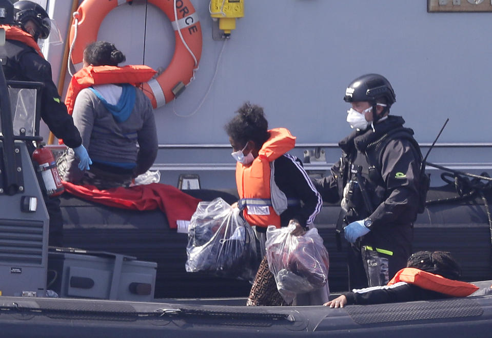 A Border Force vessel brings a group of people thought to be migrants into the port city of Dover, England, from small boats, Saturday Aug. 8, 2020. The British government says it will strengthen border measures as calm summer weather has prompted a record number of people to attempt the risky sea crossing in small vessels, from northern France to England. (AP Photo/Kirsty Wigglesworth)