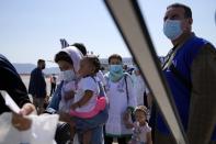 Afghan refugees wearing face masks to prevent the spread of the coronavirus, board an airplane bound for Portugal at the Eleftherios Venizelos International Airport in Athens, on Tuesday, Sept. 28, 2021. The 41 refugees from Afghanistan were relocated as part of a migrant reunification plan agreed between the two countries. (AP Photo/Thanassis Stavrakis)