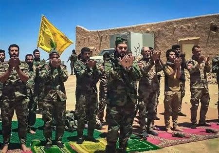 Akram Kaabi, the leader of Nujaba, leads prayers with Nujaba fighters in the town of Qayrawan, west of Mosul in this handout picture released by Tasnim News Agency on May 27, 2017. Tasnim News Agency/Handout via REUTERS