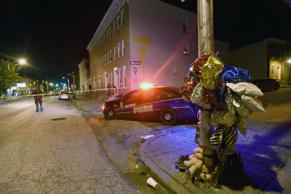 <p>A previously created memorial, right, stands as Baltimore police work at a scene where multiple people were shot in Baltimore, Saturday night, Sept. 24, 2016. Police said that none of the shootings were fatal. (AP Photo/Steve Ruark)</p>