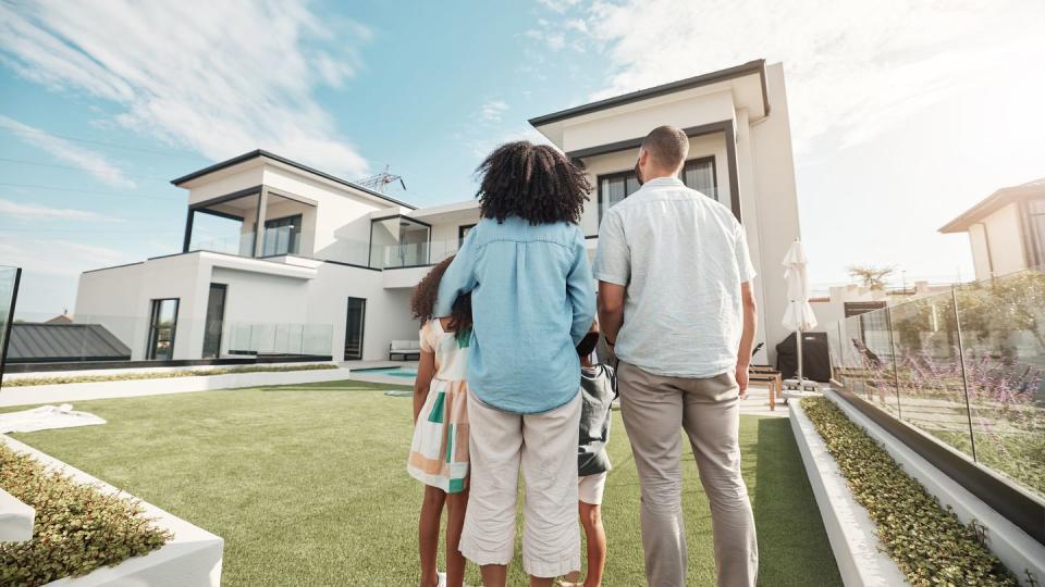 love, new house and family in their backyard together looking at their property or luxury real estate embrace, mortgage and parents with their children on grass at their home or mansion in canada