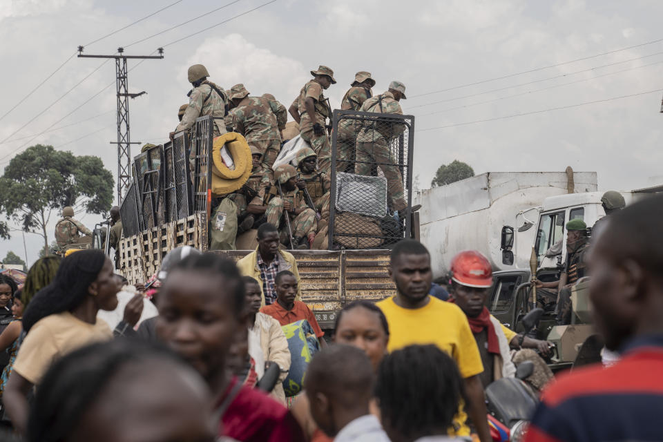 South African troops drive past thousands who are fleeing the ongoing conflict between government forces and M-23 rebels reach the entrance the Democratic Republic of Congo eastern city of Goma Wednesday, Feb. 7, 2024. (AP Photo/Moses Sawasawa)