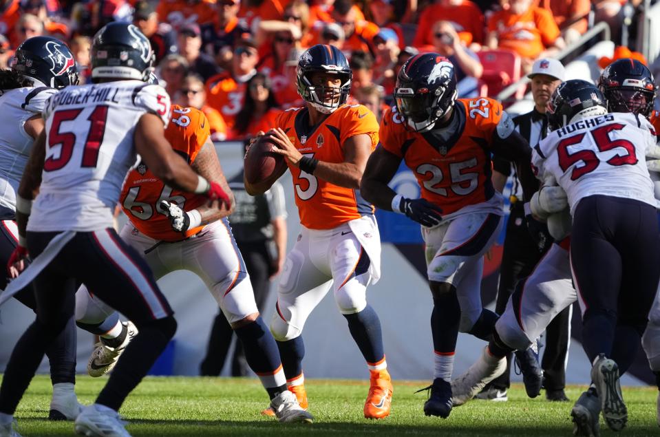 Russell Wilson looks to pass against the Houston Texans at Empower Field at Mile High.