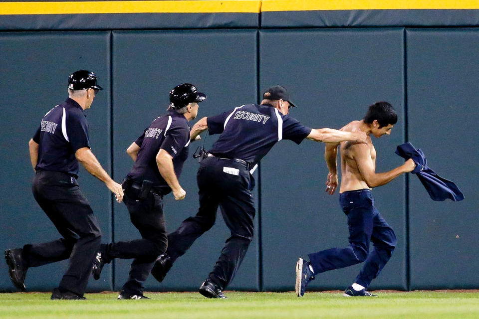 Chicago White Sox security apprehends one of the three fans that ran onto the field during the ninth inning of the game between the Chicago White Sox and the Seattle Mariners at U.S. Cellular Field on August 25, 2016 in Chicago, Illinois. (Photo by Jon Durr/Getty Images)
