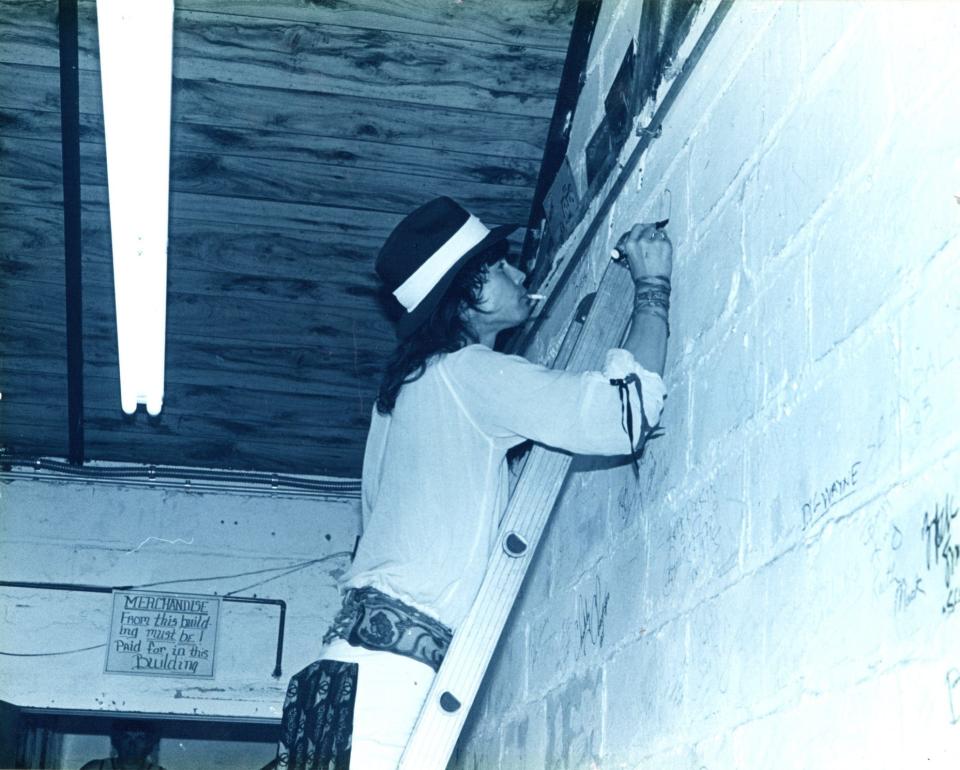 A young Steven Tyler autographs a wall in the backroom of storied Irondequoit music store the House of Guitars.