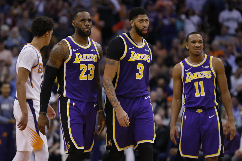 FILE- In this Nov. 12, 2019 file photo, Angeles Lakers forward LeBron James (23) and Anthony Davis (3) look on during the first half during an NBA basketball game against the Phoenix Suns in Phoenix. Davis’ status is uncertain with the restart of the NBA season looming. Davis, who left the Los Angeles Lakers’ second scrimmage after getting poked in the eye and didn’t play in the team’s exhibition finale at Walt Disney World, didn’t practice on Tuesday, July 28, 2020. (AP Photo/Rick Scuteri, File)