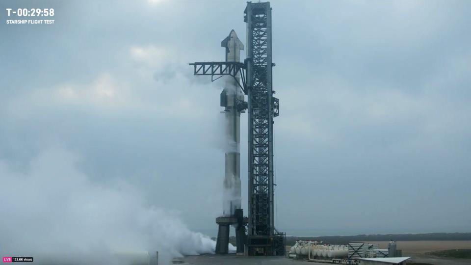 Starship rocket stands tall in steam on the launch pad