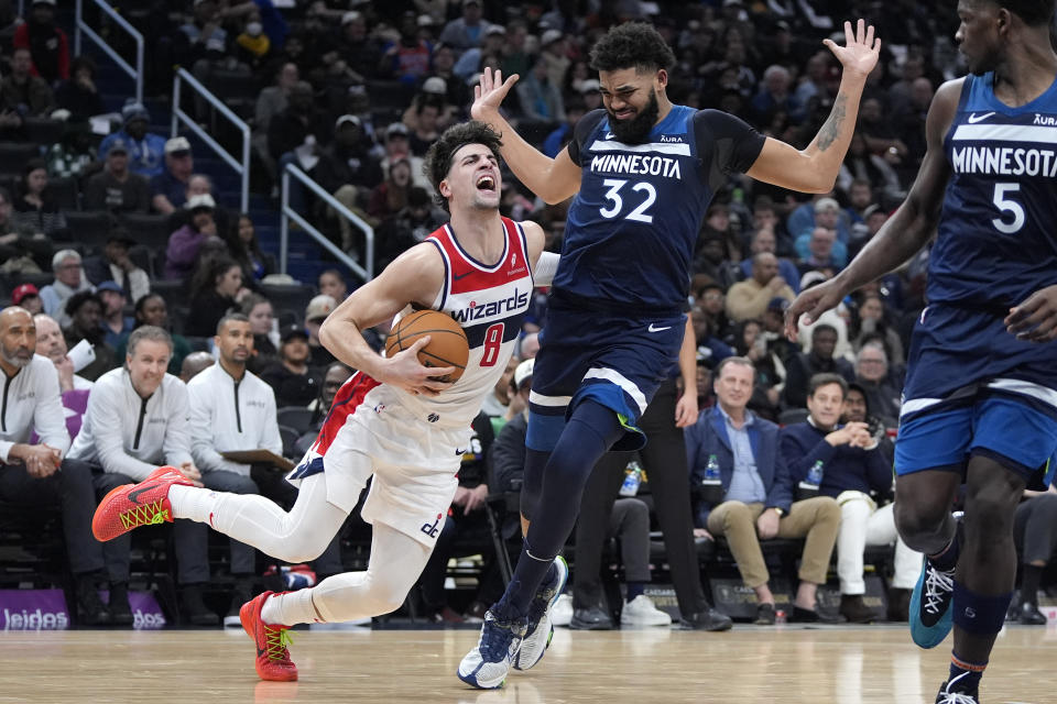 Washington Wizards forward Deni Avdija (8) is fouled by Minnesota Timberwolves center Karl-Anthony Towns (32) during the first half of an NBA basketball game Wednesday, Jan. 24, 2024, in Washington. (AP Photo/Mark Schiefelbein)
