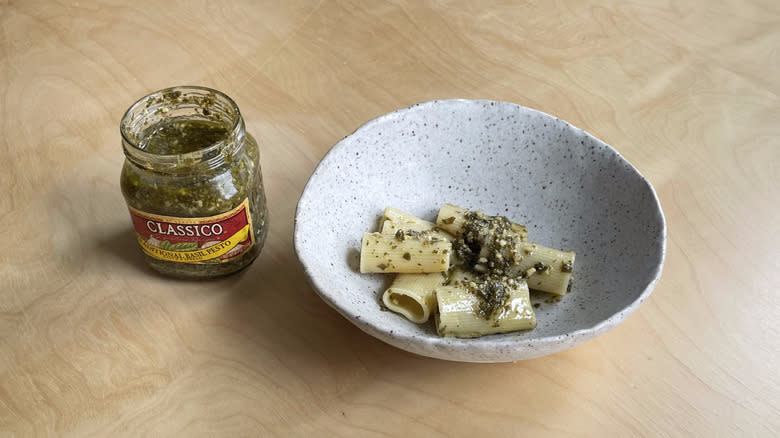 pesto jar next to pasta bowl 