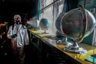 A worker sprays disinfectant at school to prevent the spread of coronavirus disease (COVID-19) in Bogor, near Jakarta