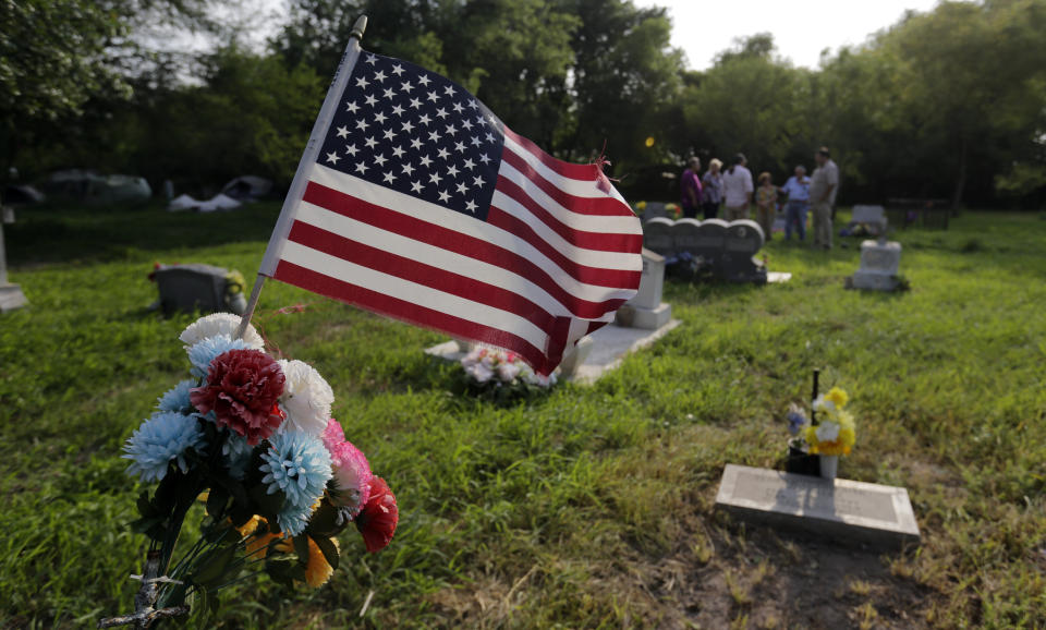 In this Wednesday, May 1, 2019 photo, family members gather at the Eli Jackson Cemetery in San Juan, Texas. Under current plans for the border wall, one of the 19th century cemeteries could be lost entirely. Some graves would have to be exhumed; others without a headstone might be paved over. (AP Photo/Eric Gay)