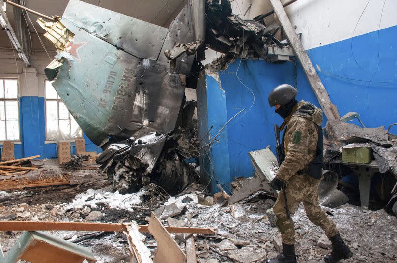 Ukrainian serviceman walks past the vertical tail fin of a Russian Su-34 bomber lying in a damaged building in Kharkiv, 8 March 2022