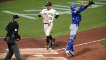 Pittsburgh Pirates' Bryan Reynolds (10) scores next to Chicago Cubs catcher P.J. Higgins on a double by Cal Mitchell off Cubs starting pitcher Javier Assad during the third inning of a baseball game in Pittsburgh, Friday, Sept. 23, 2022. Umpire Ryan Wills is at left. (AP Photo/Gene J. Puskar)