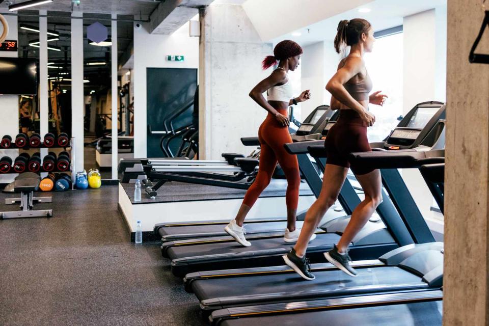 <p>Getty</p> Two unrecognizable female friends working out on a treadmill at the gym