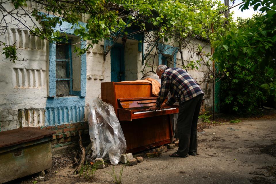 Local resident Anatolii Virko plays a piano outside a house likely damaged after a Russian bombing in Velyka Kostromka village, Ukraine, on Thursday.