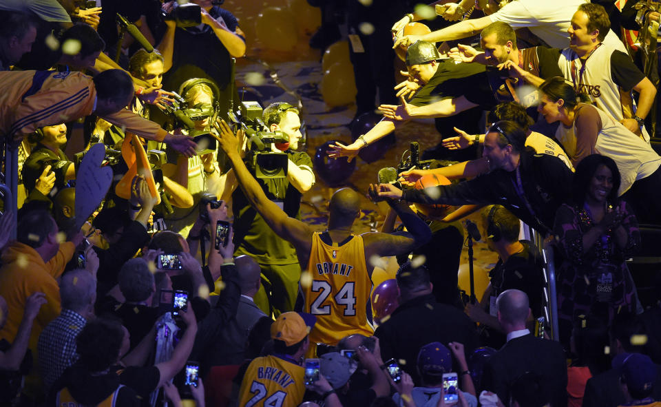 Kobe Bryant walks off the court surrounded by fans and photographers after his last NBA game before retiring on April 13, 2016.