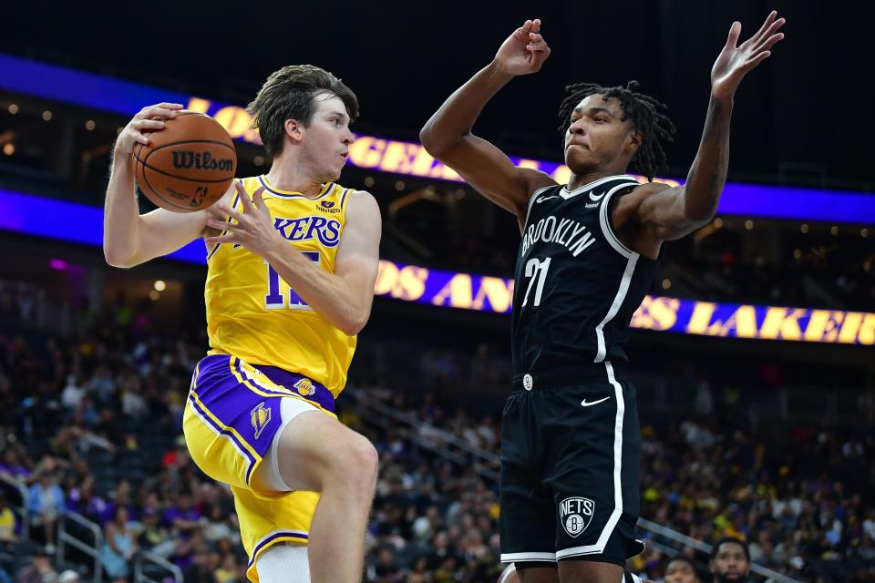 Los Angeles Lakers guard Austin Reaves passes the ball against the defense of Brooklyn Nets forward Noah Clowney during the second half at T-Mobile Arena.