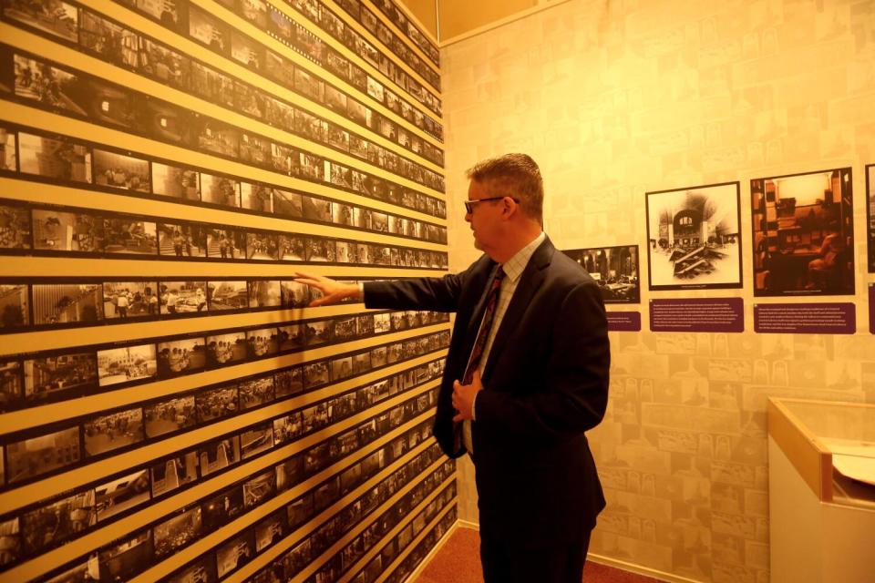 City Librarian John Szabo looks over a contact sheet of photographs created of the fire that struck the library in 1986.