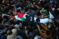 <p>Mourners and journalists carry the body of Palestinian journalist Yasser Murtaja, during his funeral in Gaza City on April 7, 2018. Among those killed at Friday’s protest was Yasser Murtaja, a photographer with the Gaza-based Ain Media agency, who died from his wounds after being shot, the local health ministry said. Murtaja’s company confirmed his death, with witnesses saying he was close to the front of the protests in Southern Gaza when he was hit. (Photo: Majdi Fathi/NurPhoto via Getty Images) </p>