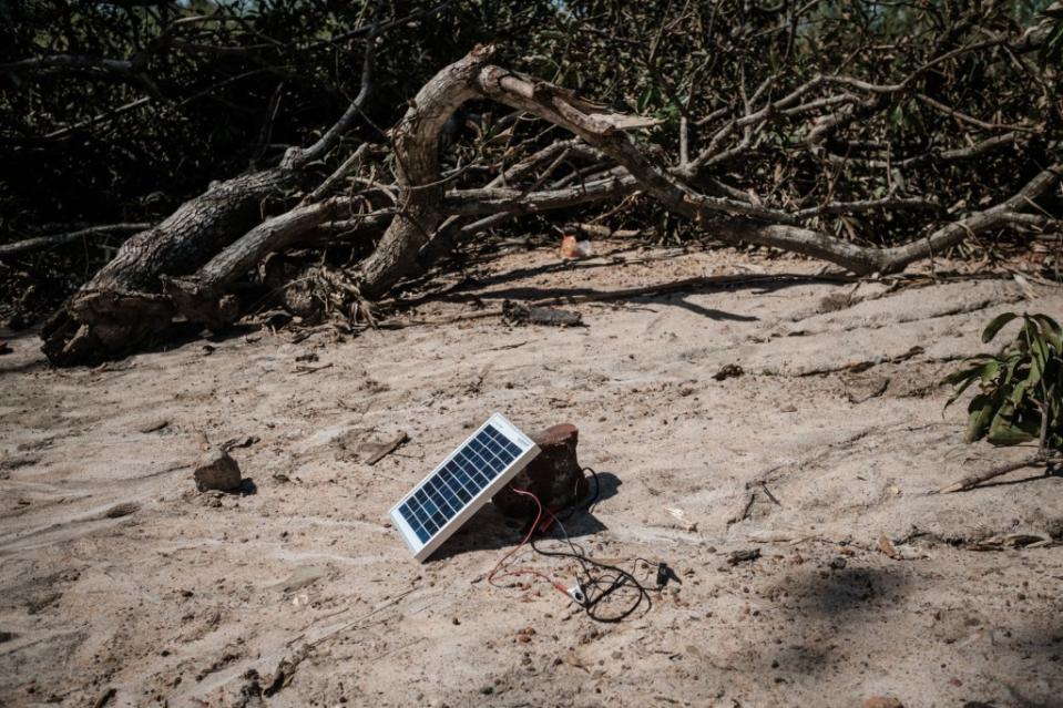 A solar charger is seen beside trees destroyed when a deadly cyclone hit Tica, Mozambique, in March 2019. The country is one of two that the heads of the EPA and NAACP will visit on their climate mission. (Photo by Yasuyoshi Chiba/AFP via Getty Images)