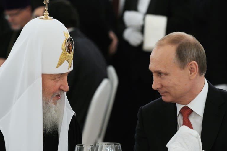 Patriarch Kirill (L) speaks with President Vladimir Putin (R) during the presidential reception in the Kremlin on July 28, 2015 marking 1,000 years since the death of Prince Vladimir