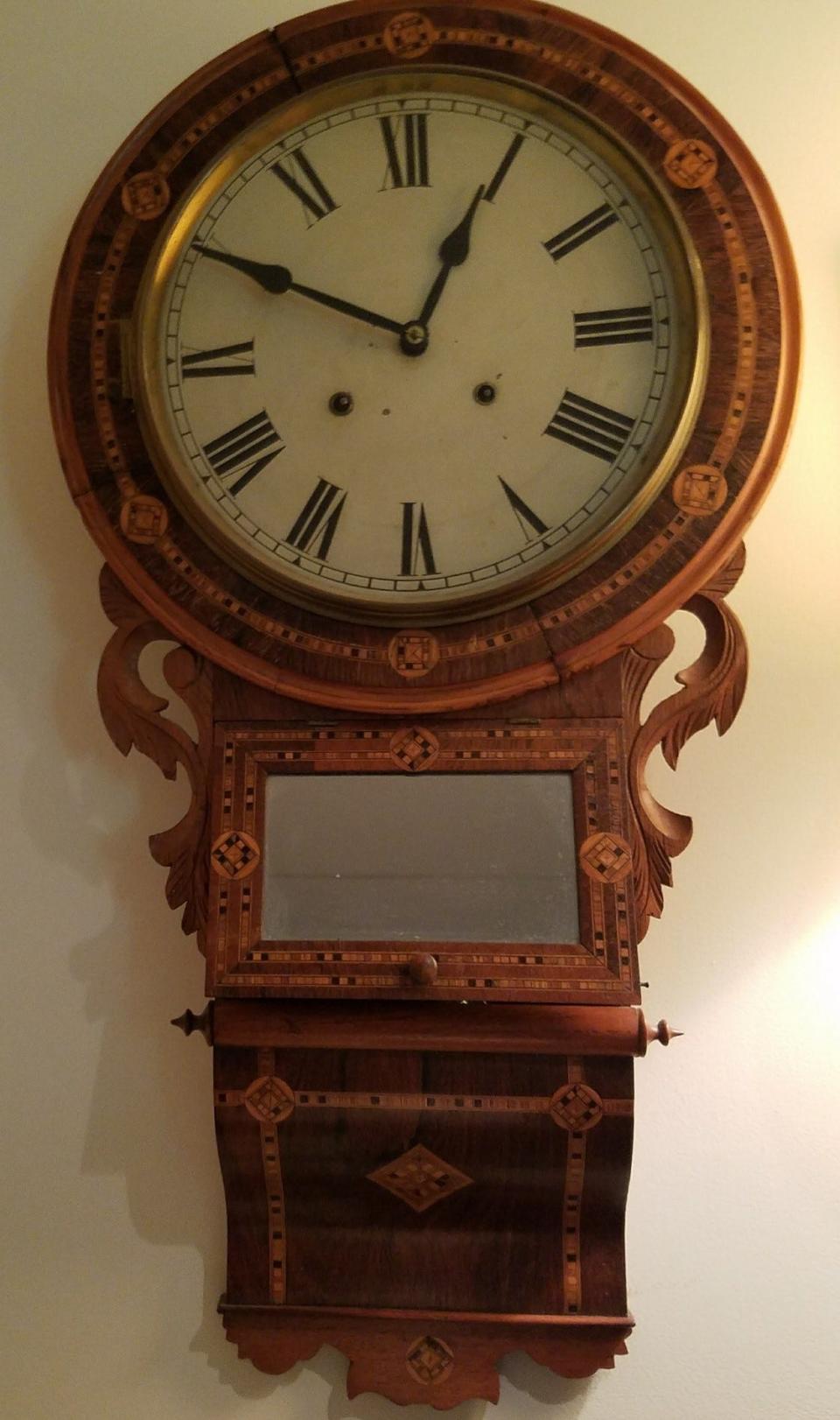 Wall clock with pendulum and a marquetry-decorated wood case.