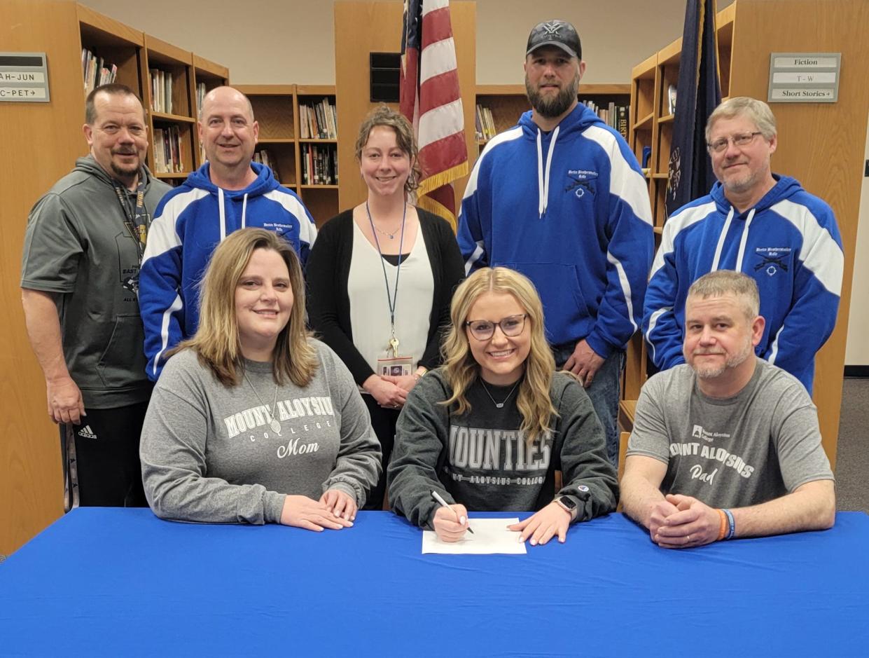 Flanked by parents Holly and Jonathan Hayman, Berlin Brothersvalley senior student-athlete Samantha Hayman announces her intentions to attend Mount Aloysius College and compete on the rifle team, March 27, in Berlin. In back, from left, Berlin Athletic Director Doug Paul, assistant rifle coaches Trevor Pritts, Holly Montgomery, Ben Whipkey and head coach Eric Johnson.