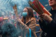 Worshippers wear masks to prevent an outbreak of a new coronavirus as they make offerings of incense sticks during a Lunar New Year celebration at Che Kung Temple, in Hong Kong