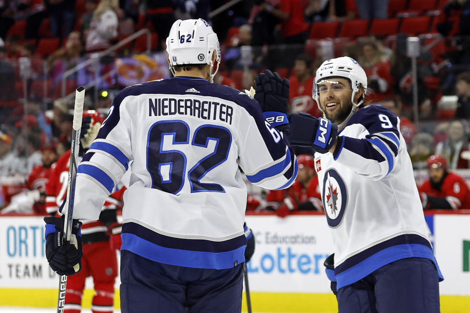 Winnipeg Jets' Alex Iafallo (9) congratulates teammate Nino Niederreiter (62) on his second goal against the Carolina Hurricanes during the third period of an NHL hockey game in Raleigh, N.C., Saturday, March 2, 2024. (AP Photo/Karl B DeBlaker)