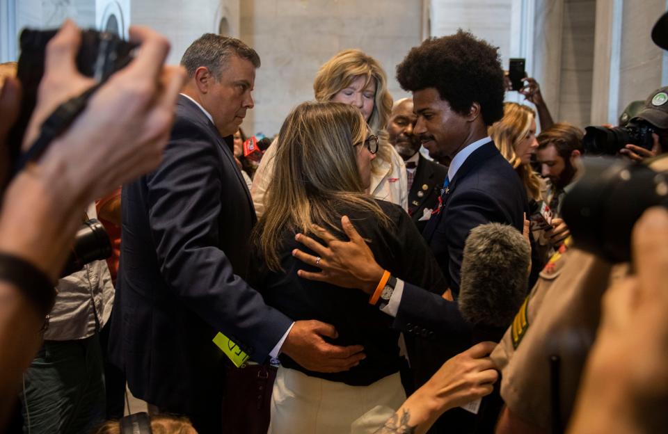 Rep. Jason Powell, D- Nashville, puts his arm around Sarah Shoop Neumann, Covenant parent, across from Rep. Gloria Johnson, D- Knoxville, while Shoop Neumann looks to Rep. Justin Pearson, D-Memphis, following the last day of a legislative session on public safety in Nashville, Tenn., on Tuesday, August 29, 2023.