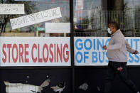 FILE - In this Thursday, May 21, 2020, file photo, a man looks at signs of a closed store due to the coronavirus pandemic, in Niles, Ill. State governments are pushing for help from Congress to fix budget gaps caused by the coronavirus pandemic and economic shutdowns. (AP Photo/Nam Y. Huh, File)