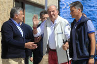 Spain's former King Juan Carlos, centre, waves before a reception at a nautical club prior to a yachting event in Sanxenxo, north western Spain, Friday, May 20, 2022. Spain's former King has returned to Spain for his first visit since leaving nearly two years ago amid a cloud of financial scandals. (AP Photo/Lalo R. Villar)