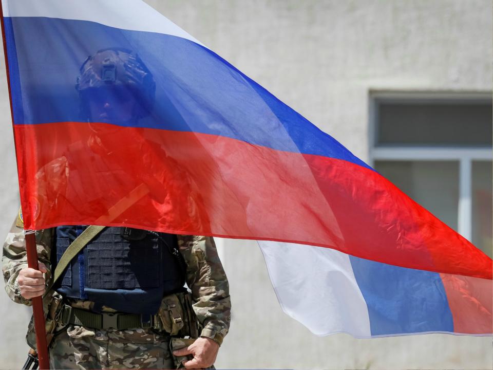 A member of Russia's special operations unit stands with a national flag. The US Treasury just imposed new sanctions on three Russians and five Russian companies for suspected cyber attacks: REUTERS/Shamil Zhumatov