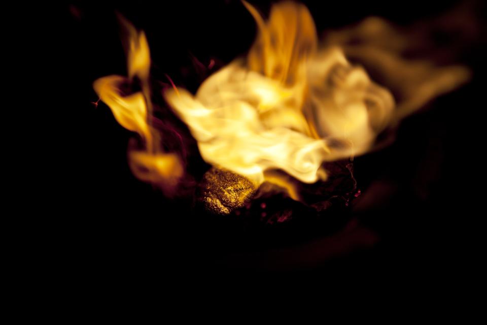 In this May 5, 2014 photo, a miner melts an amalgam of gold and mercury to burn off the mercury in front of a seller, in La Pampa in Peru's Madre de Dios region. A 21st-century gold rush began in Peru in 2008. Thousands sweat through 28-hour shifts and endure, for a few grams of gold, the perils of collapsing earth, limb-crushing machinery and the toxic mercury used to bind gold flecks. (AP Photo/Rodrigo Abd)