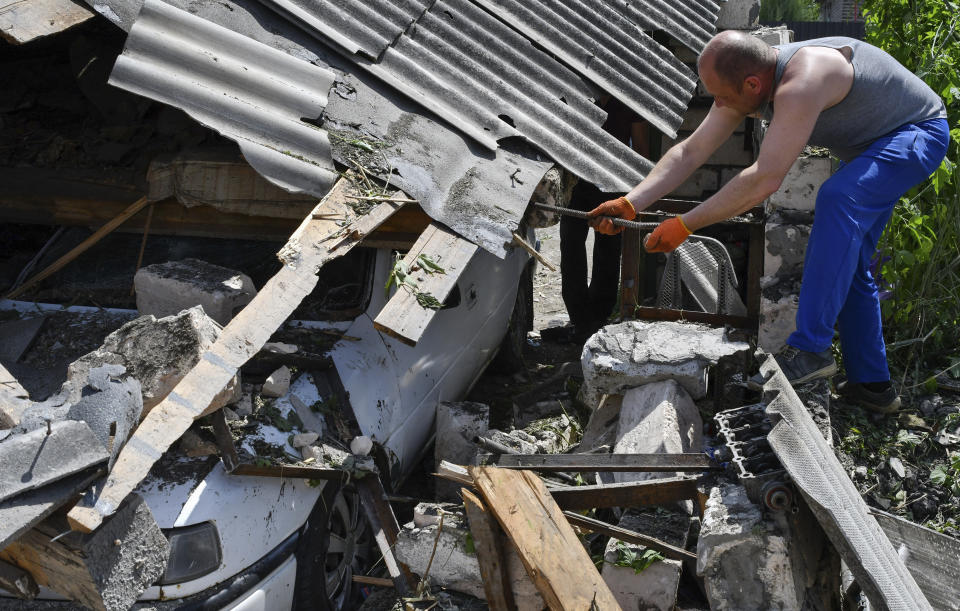 A resident removes debris from a destroyed house after Russian shelling in Kramatorsk, Ukraine, Wednesday, May 25, 2022. (AP Photo/Andriy Andriyenko)