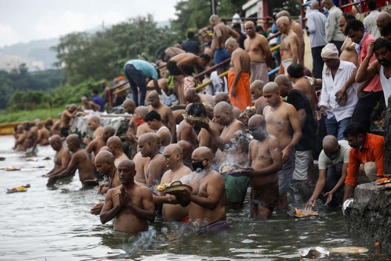 Devotees pray as they take a dip in a lake to honour the souls of their departed ancestors on the auspicious day of Mahalaya, amid the spread of the coronavirus disease (COVID-19) in Mumbai, India