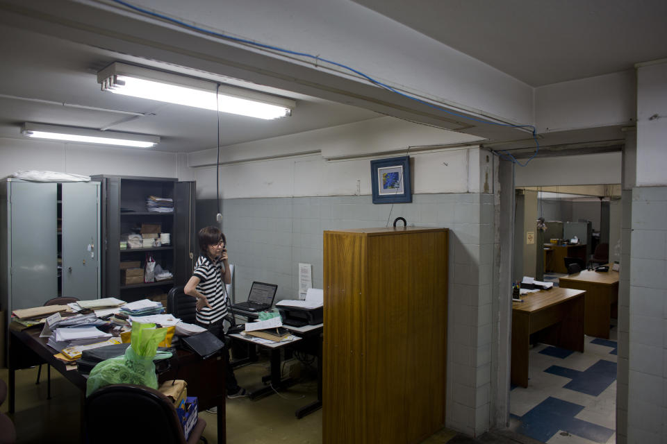 In this Dec. 26, 2018 photo, Nabuko Kojo, administrative director of the Japanese newspaper Sao Paulo Shimbun answers the phone as she empties her desk in Sao Paulo, Brazil. The Sao Paulo Shimbun printed its final edition on Jan. 1, 2019, decades after it was founded shortly after the end of World War II. (AP Photo/Victor R. Caivano)