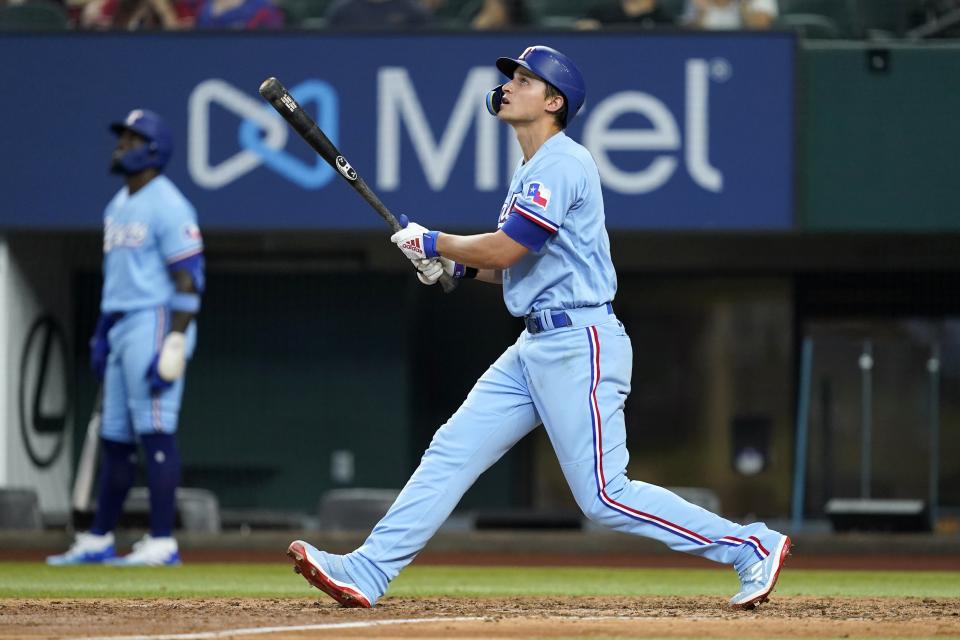 Texas Rangers' Corey Seager watches the flight of his run-scoring sacrifice fly in the fifth inning of a baseball game against the Minnesota Twins, Sunday, July 10, 2022, in Arlington, Texas. (AP Photo/Tony Gutierrez)