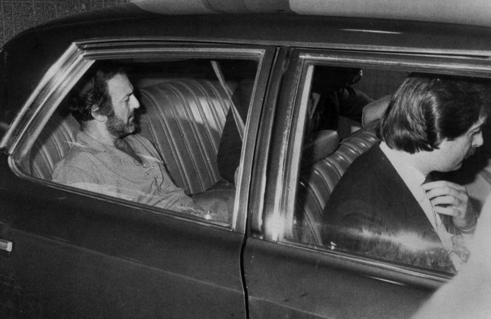 Erie police drive Caesar Montevecchio, left, 49, to his arraignment on burglary charges on Aug. 11, 1983.