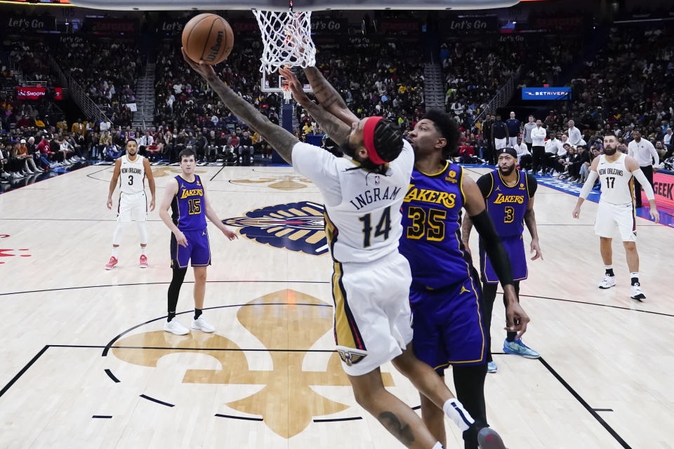 New Orleans Pelicans forward Brandon Ingram (14) goes to the basket against Los Angeles Lakers forward Christian Wood (35) in the second half of an NBA basketball game in New Orleans, Sunday, Dec. 31, 2023. The Pelicans won 129-109. (AP Photo/Gerald Herbert)
