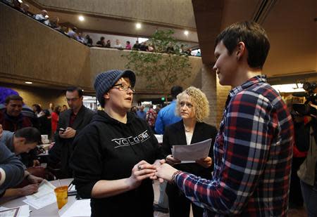 Nicole Barnes (L) and her partner Tarah Camarillo exchange rings as they get married at the Salt Lake County Government Building in Salt Lake City, Utah, December 23, 2013. REUTERS/Jim Urquhart