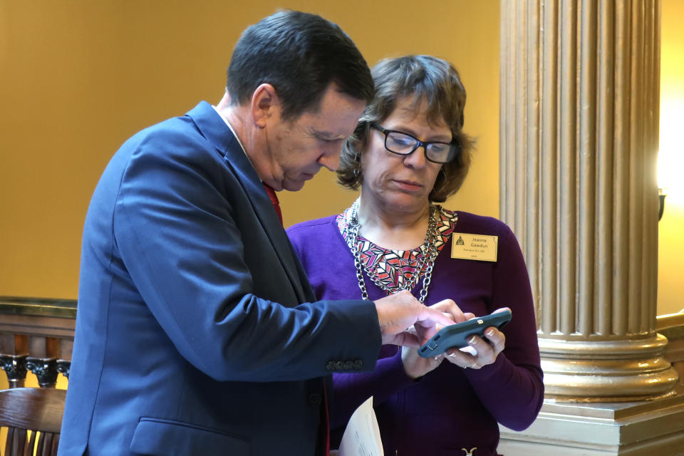 Kansas state Sen. Dennis Pyle, left, R-Hiawatha, consults with Jeanne Gawdun, right, a Kansans for Life lobbyist, following a meeting of GOP senators about a proposed amendment to the state constitution on abortion, Wednesday, Jan. 29, 2020, at the Statehouse in Topeka, Kan. The amendment would overturn a Kansas Supreme Court decision protecting abortion rights, and critics say it could lead eventually to a ban on abortion. (AP Photo/John Hanna)