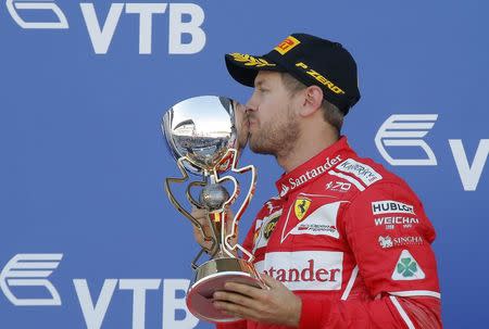 Formula One - F1 - Russian Grand Prix - Sochi, Russia - 30/04/17 - Second-placed Ferrari Formula One driver Sebastian Vettel of Germany kisses the trophy on the podium. REUTERS/Maxim Shemetov