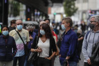 People wearing face masks to prevent the spread of coronavirus queue to buy lottery tickets in downtown Madrid, Spain, Friday, Sept. 18, 2020. With more than 11,000 new daily coronavirus cases, the attention in Spain is focusing on its capital, where officials are mulling localized lockdowns and other measures to bring down the curve of contagion. (AP Photo/Manu Fernandez)