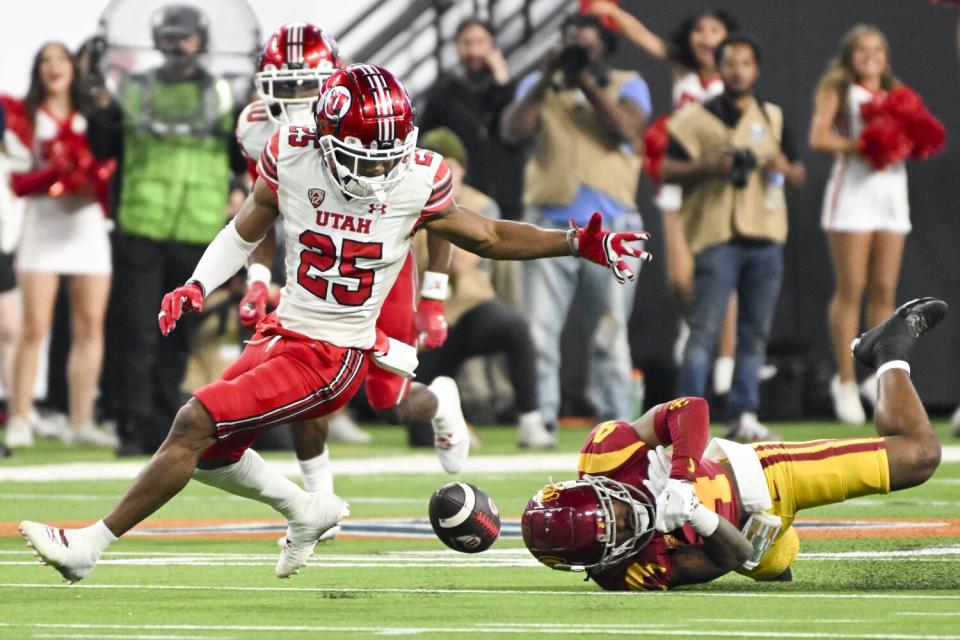 Utah wide receiver Jaylen Dixon, left, fumbles the ball next to USC defensive back Max Williams.